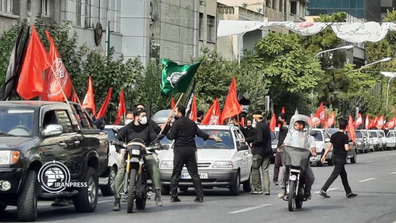 Iranpress: شاهد بالصور والفيديو.. إحياء وتعظيم الشعائر الحسينية في طهران بمسيرات رمزية بالسيارات 