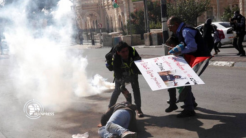 Iranpress: Zionist Forces attack Palestinian journalists supporting injured photojournalist