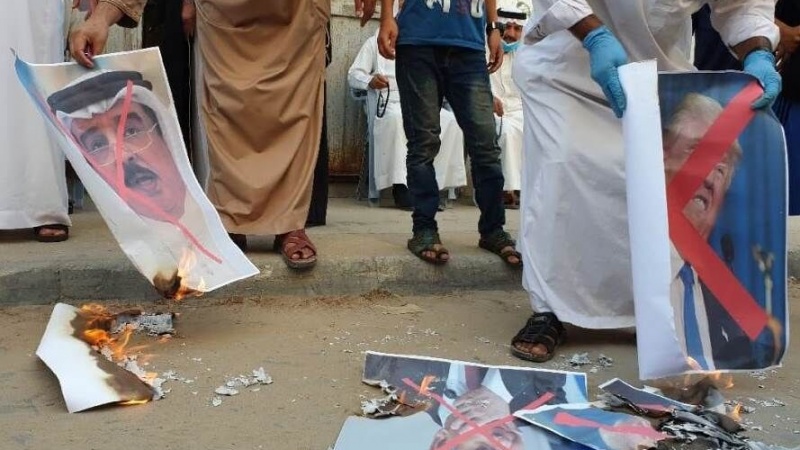 Iranpress: خشم مردم فلسطین از رژیم آل‌خلیفه؛ تصاویر حکام بحرین در غزه سوزانده شد
